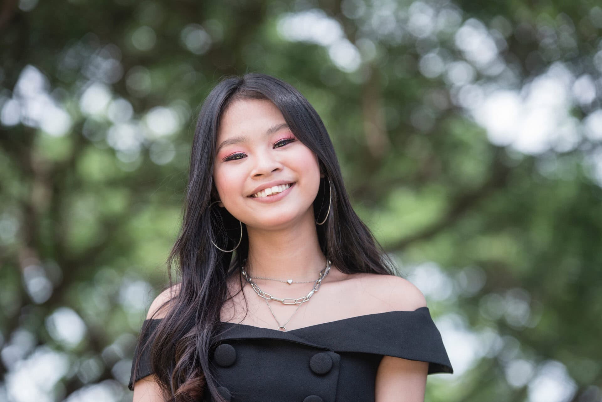 A pretty young asian teenager with overbite. A darling teen in a cute black dress.