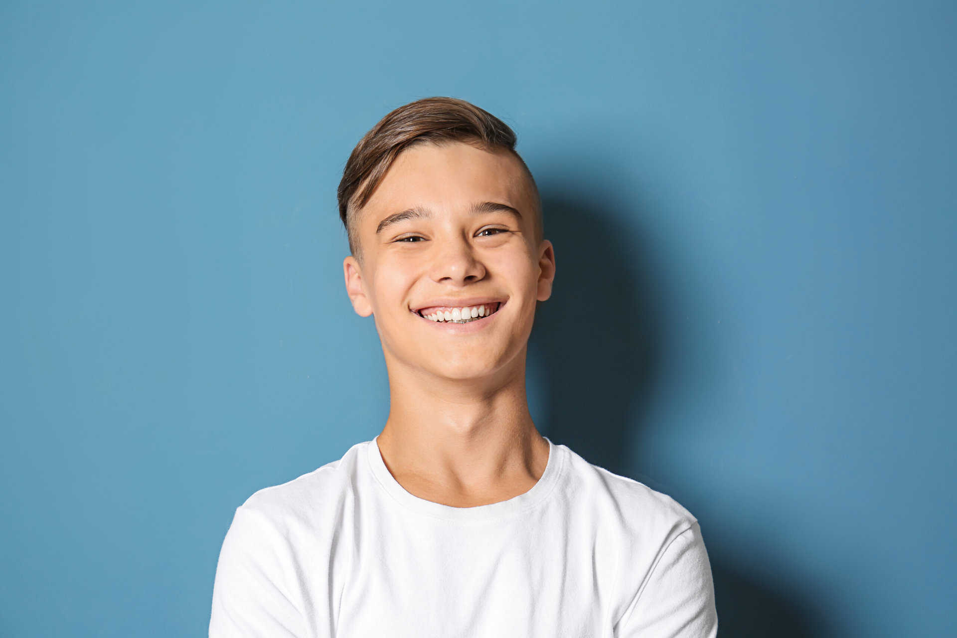 Smiling teenage boy on color background