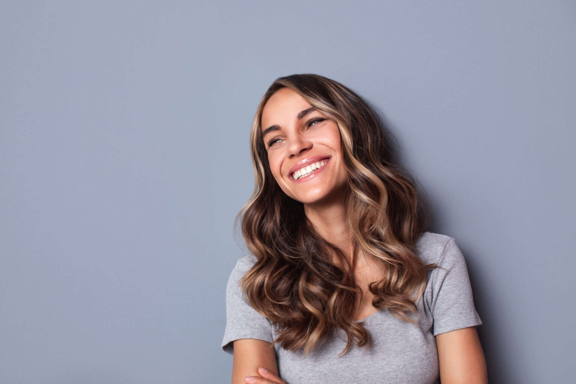 Beautiful smiling woman studio shot on gray background.